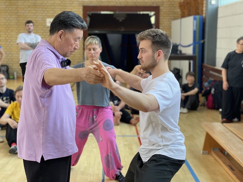 Tai Chi teacher correcting stance in class