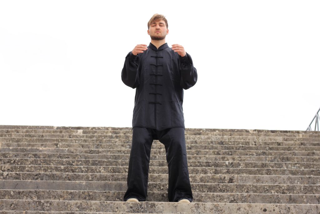 Tai Chi balance pose in front of trees